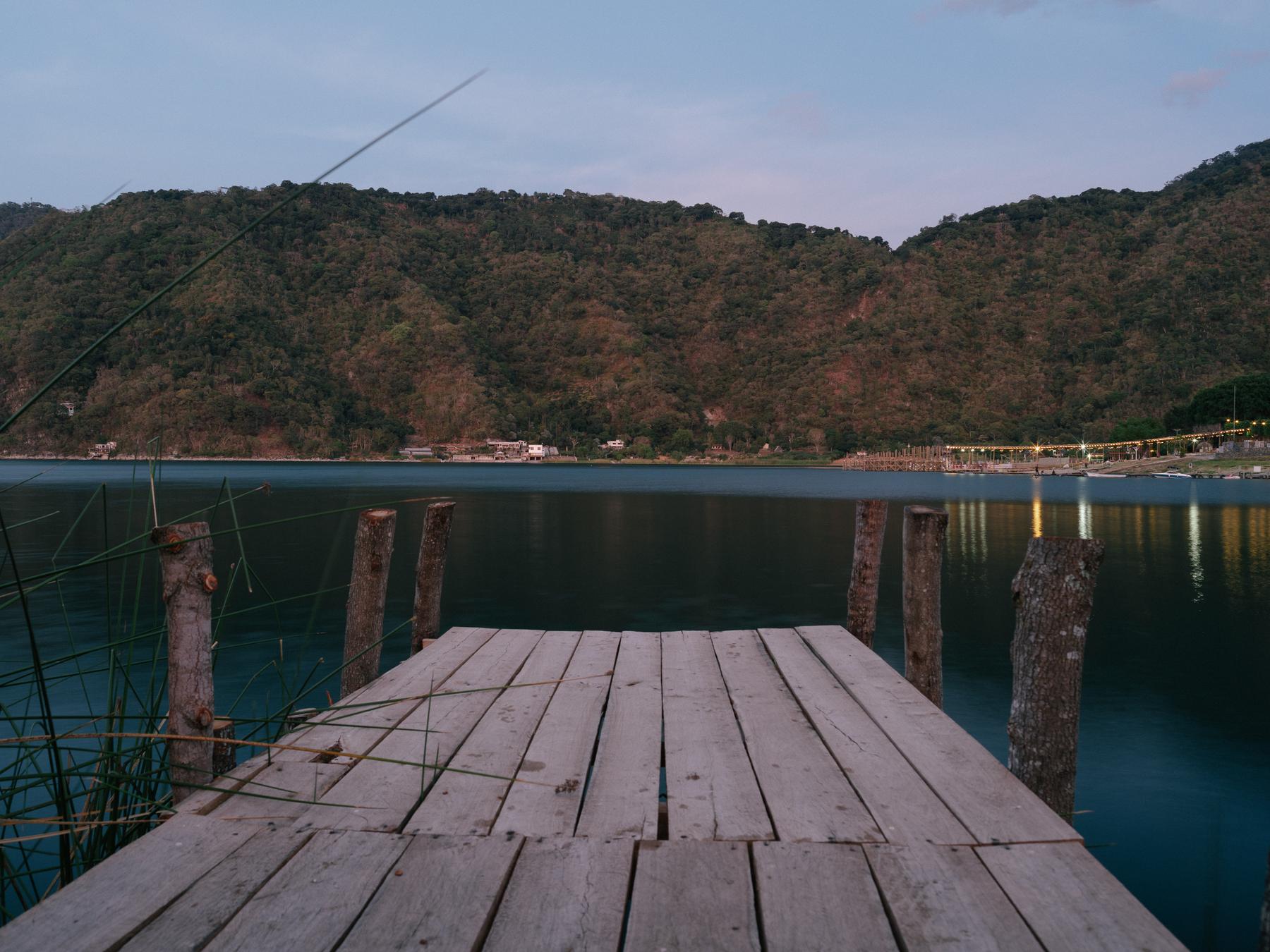 Muelle de madera de Venecia al anochecer, frente a las montañas del Lago de Atitlán